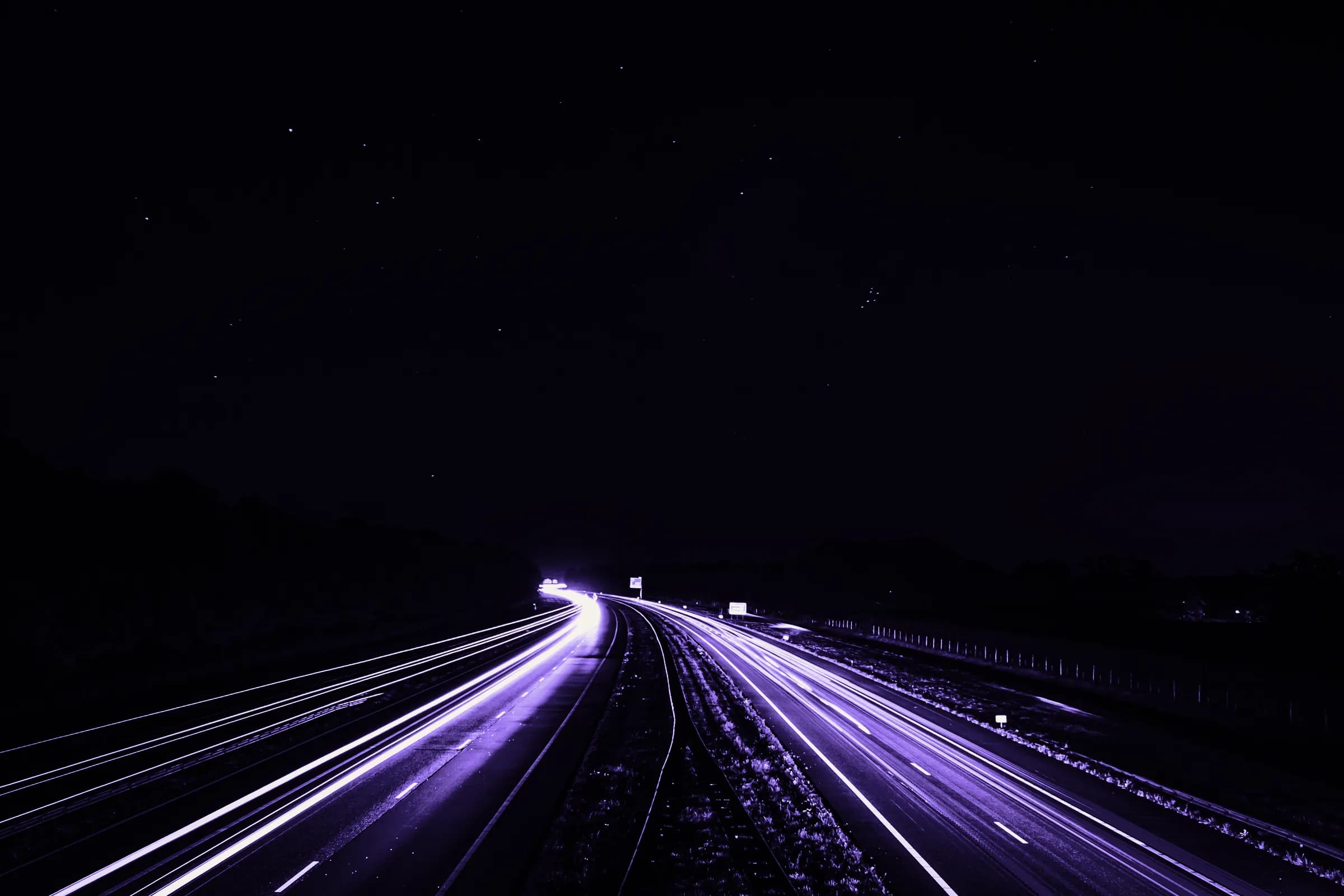 Lumini de mașini pe o autostradă noaptea, fotografiate cu expunere lungă